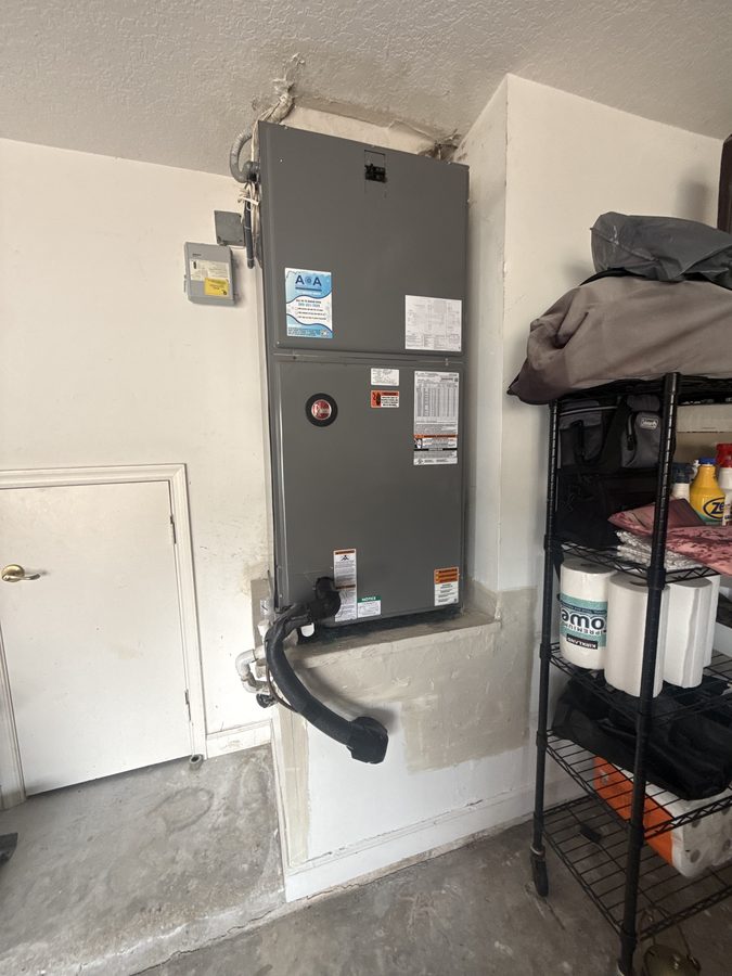 Rheem air handler set on a raised platform with disconnect, insulated suction line and condensate drain